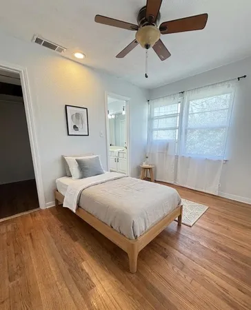 a bedroom with a large bed a chandelier and a window