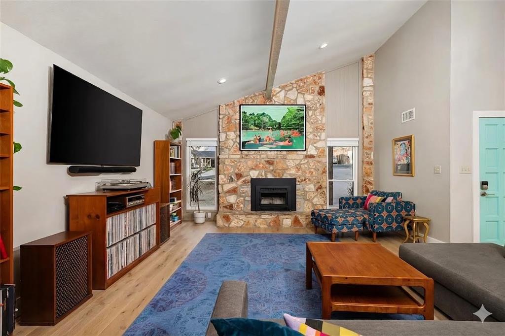 2210 Red Fox Road Austin, TX 78734 - Photo 10 of 40 A striking stone fireplace anchors this living space, offering warmth and architectural character. Wood flooring is virtually staged.