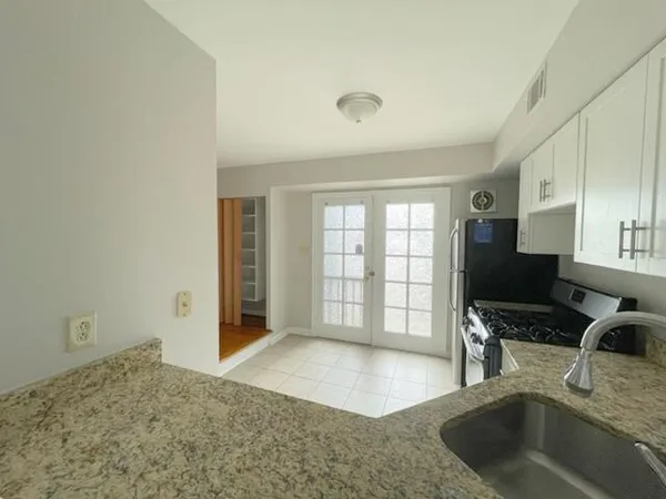 a view of a kitchen with granite countertop a sink and a stove top oven