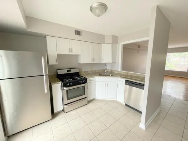 a kitchen with white cabinets and white appliances
