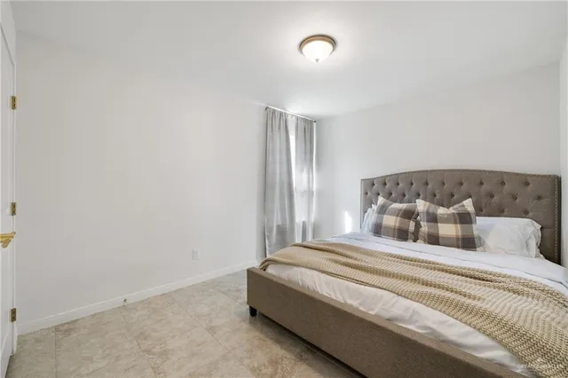 a bedroom with a large bed and a mirror