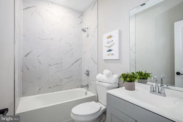 a bathroom with a sink a toilet a bathtub and shower