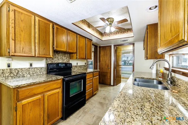 a kitchen with stainless steel appliances granite countertop a stove a sink and a microwave