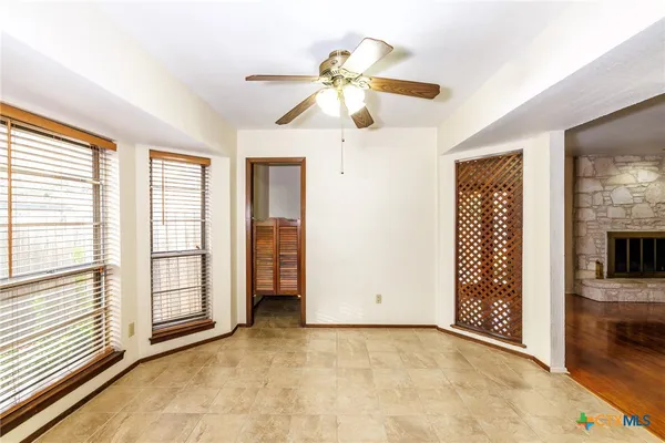 a view of an empty room with a window and a kitchen