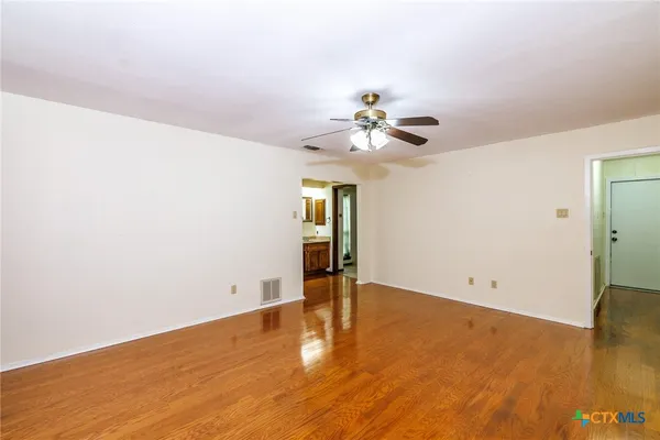 an empty room with wooden floor and window