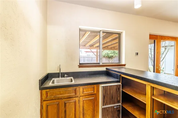 a kitchen with granite countertop cabinets sink and window