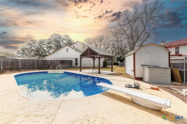 a view of a house with swimming pool and sitting area