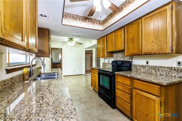 a kitchen with stainless steel appliances granite countertop a stove a sink and a microwave