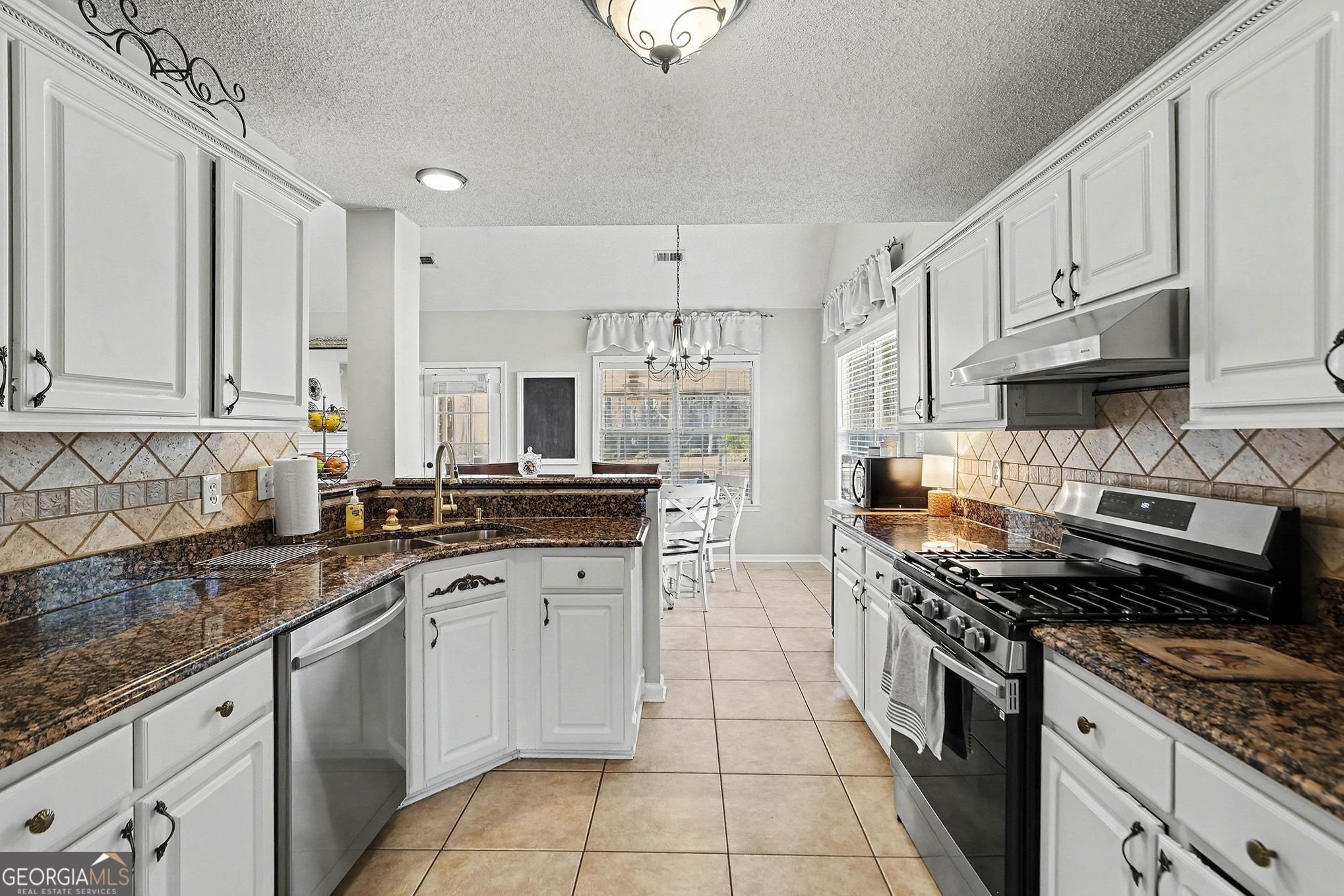 143 Pheasant Ridge Newnan, GA 30265 - Photo 6 of 27 a kitchen with stainless steel appliances granite countertop a sink stove refrigerator and cabinets
