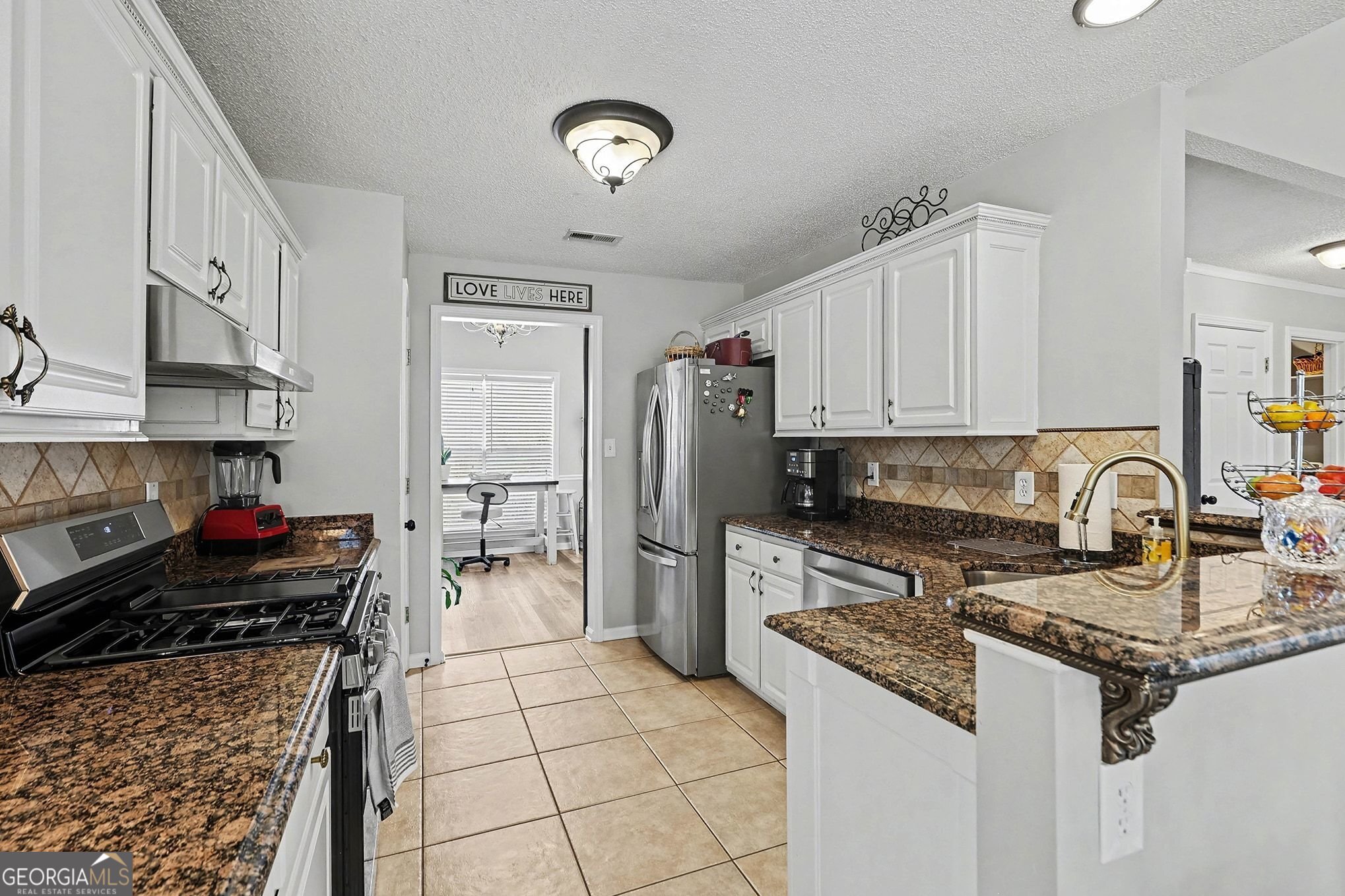 143 Pheasant Ridge Newnan, GA 30265 - Photo 8 of 27 a kitchen with stainless steel appliances granite countertop a stove refrigerator sink and cabinets
