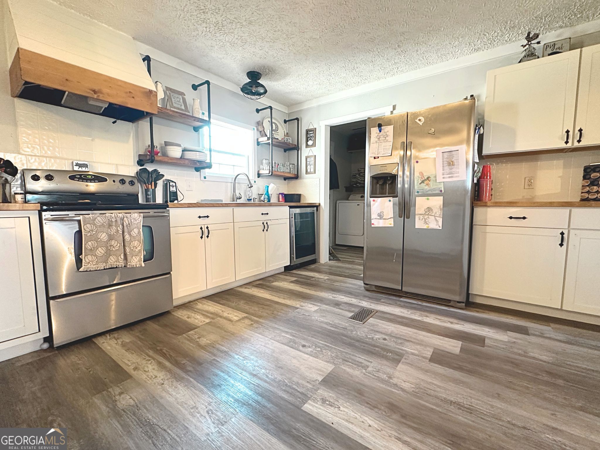1391 Blue Springs Road Buckhead, GA 30625 - Photo 14 of 36 a kitchen with stainless steel appliances a refrigerator sink and cabinets