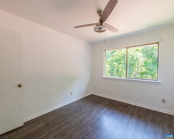 a view of a room with wooden floor and windows