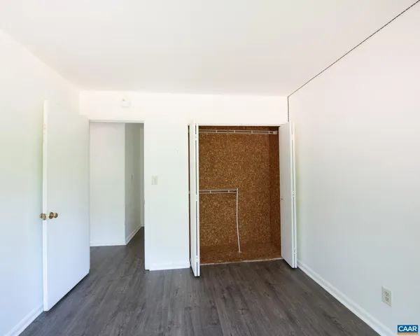 an empty room with wooden floor and closet