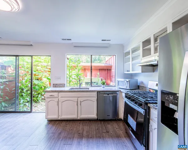 a kitchen with stainless steel appliances granite countertop a stove a sink and a refrigerator