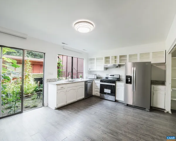 a kitchen with a refrigerator and a stove top oven