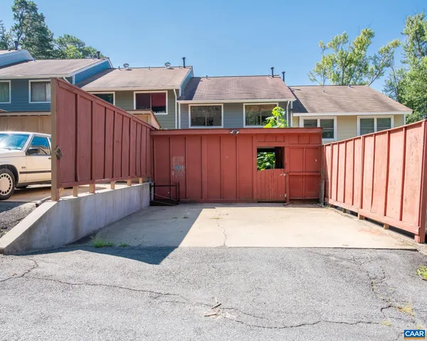 a front view of a house with parking space and a car parked in yard