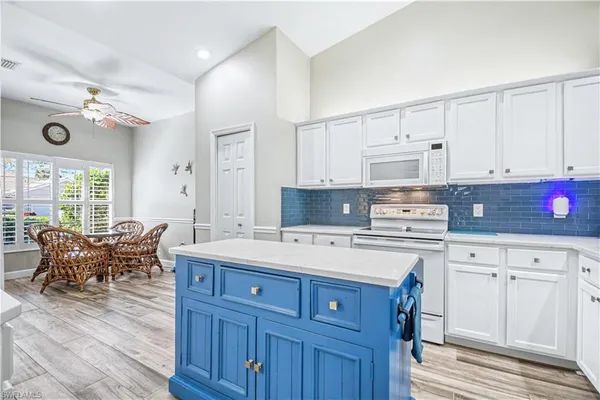 a kitchen with kitchen island granite countertop a sink cabinets and wooden floor