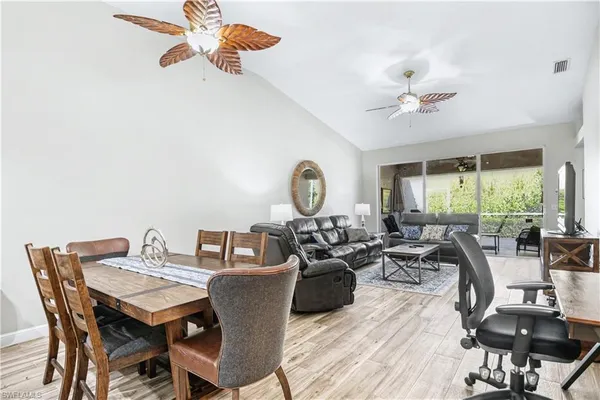 a view of a dining room with furniture a chandelier and wooden floor