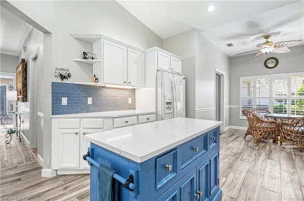 a kitchen with a stove a refrigerator and a dining table with wooden floor