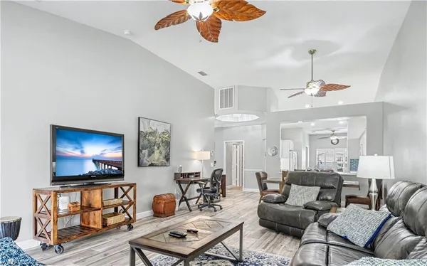 a living room with furniture a flat screen tv and a window