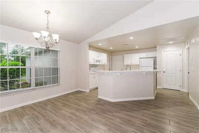 a view of a living room and kitchen with windows