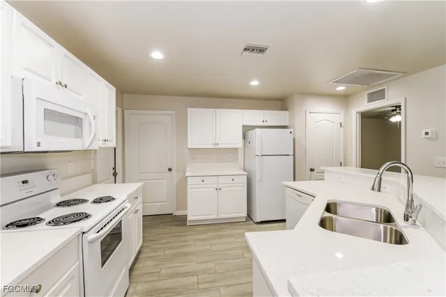 a kitchen that has a sink a stove and cabinets