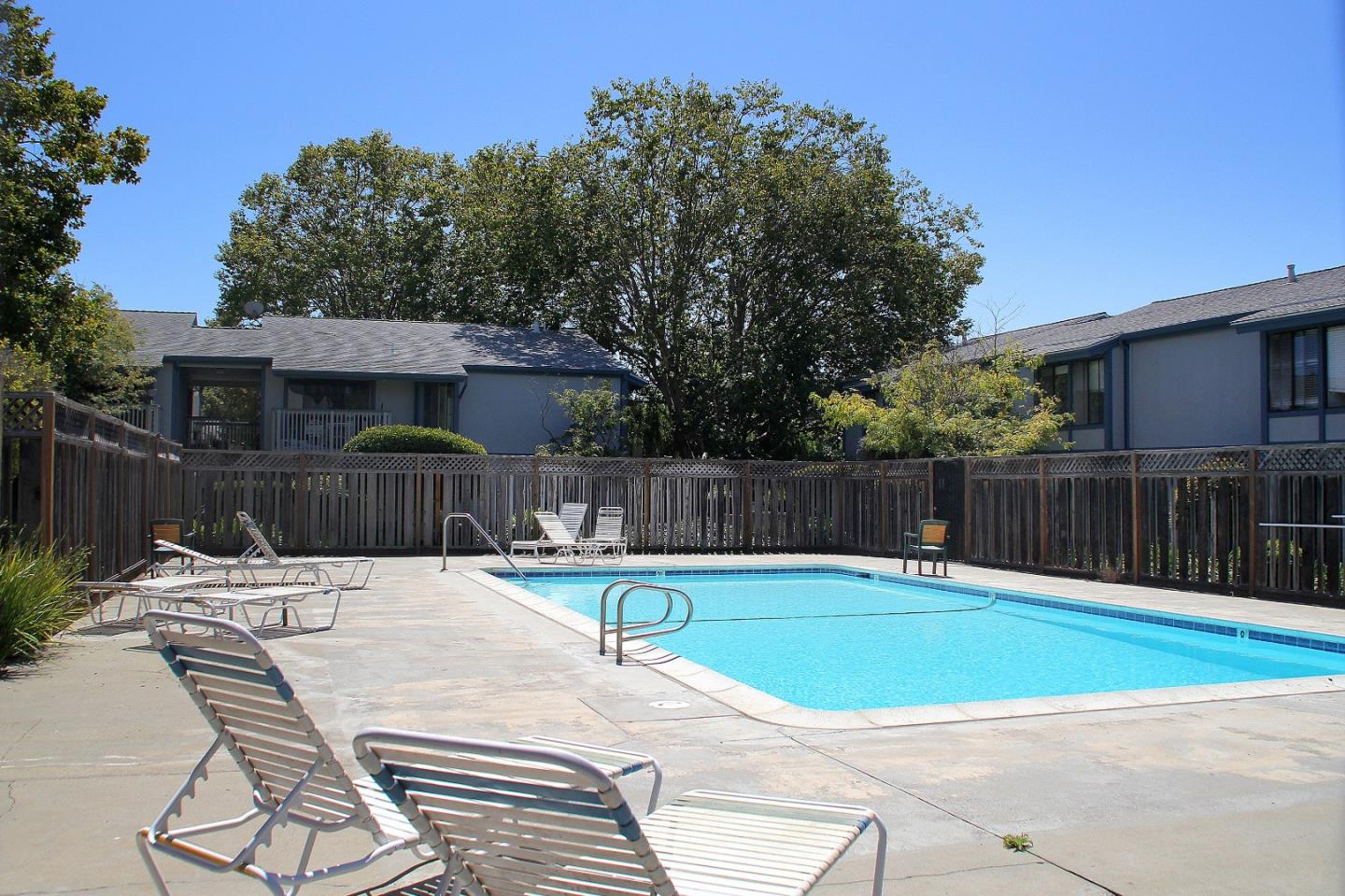 1925 46th Avenue, Unit 110 Capitola, CA 95010 - Photo 13 of 18 a view of swimming pool with table and chairs in front of house
