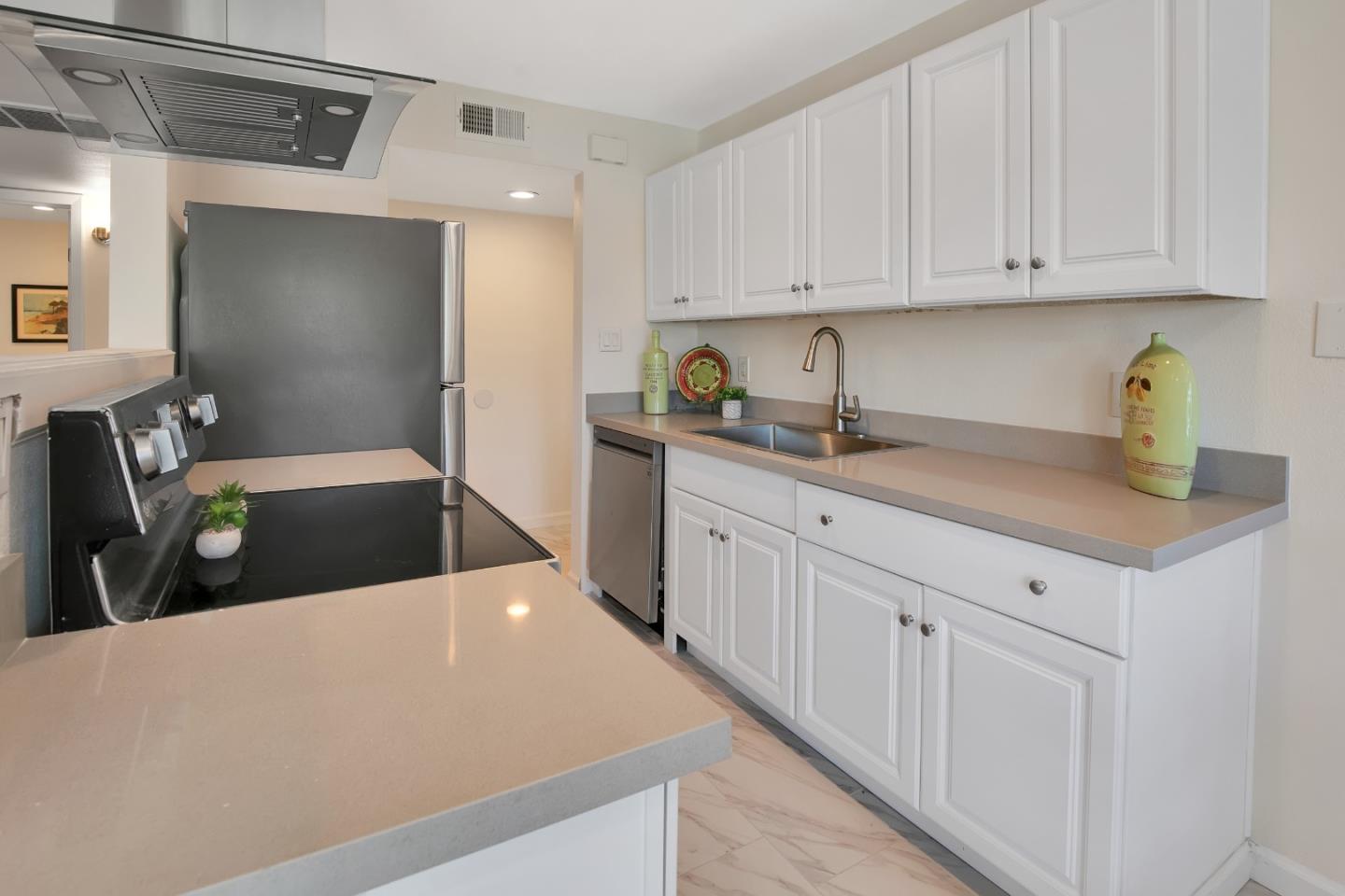 1925 46th Avenue, Unit 110 Capitola, CA 95010 - Photo 2 of 18 a kitchen with stainless steel appliances a sink cabinets and wooden floor
