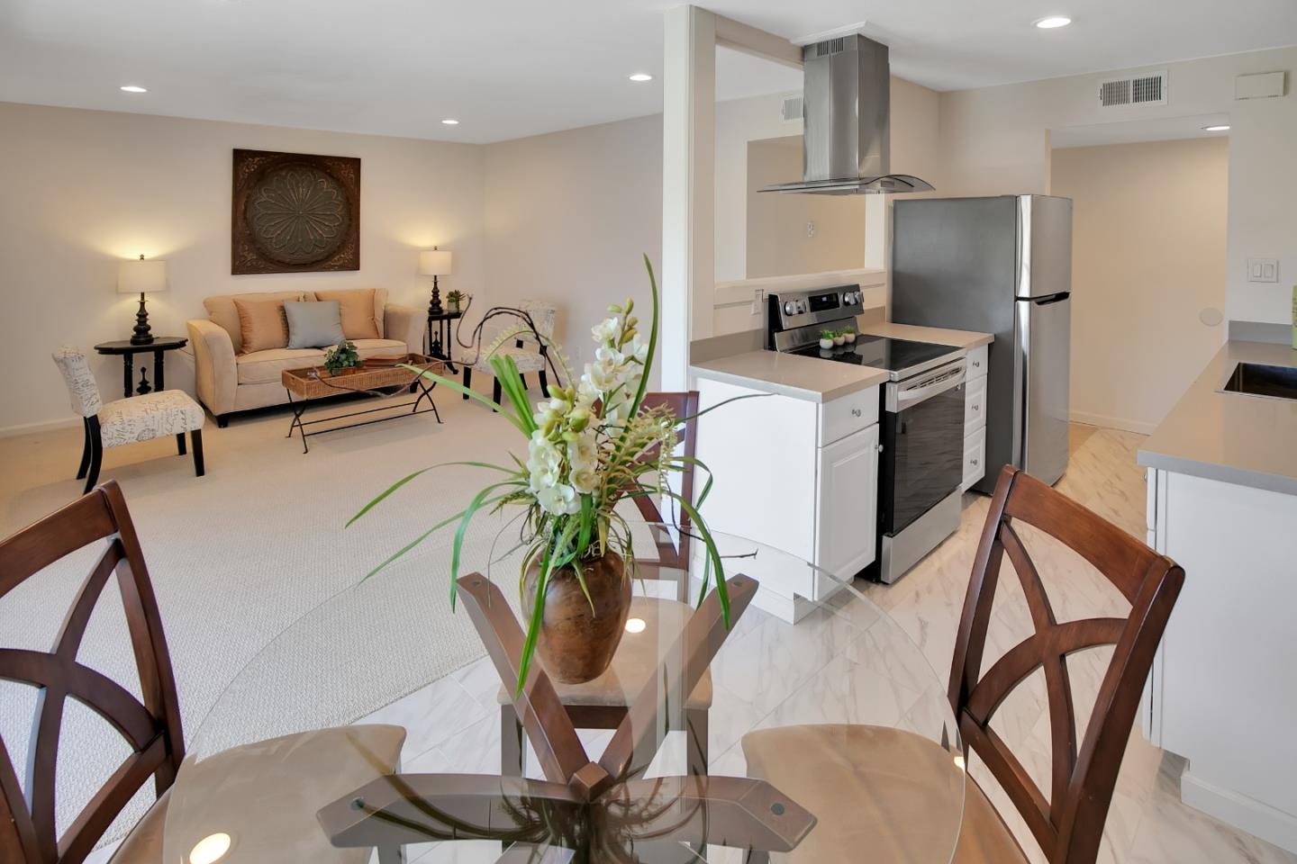 1925 46th Avenue, Unit 110 Capitola, CA 95010 - Photo 3 of 18 a living room with furniture a flat screen tv and kitchen view