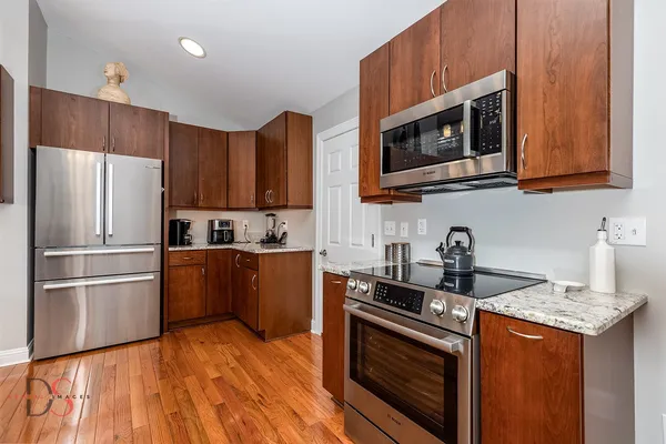 a kitchen with granite countertop wooden cabinets stainless steel appliances and a granite counter tops