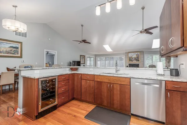 a kitchen with stainless steel appliances granite countertop a sink and dishwasher a stove with wooden floors