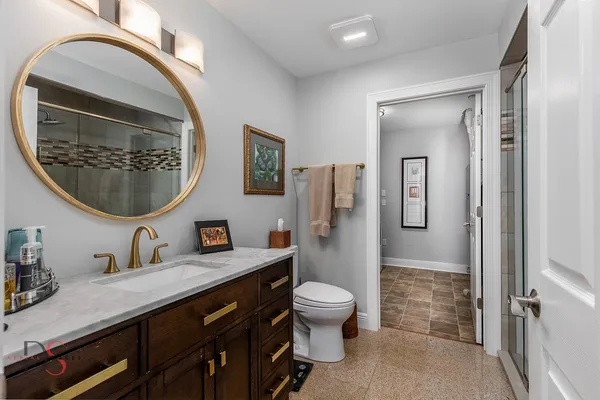 a bathroom with a granite countertop toilet a sink and a mirror