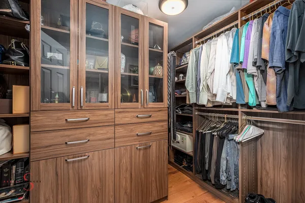 a view of walk in closet with clothes and shoes