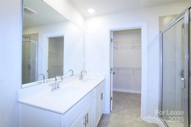 a bathroom with a double vanity sink mirror and shower