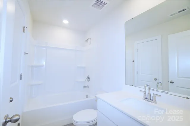 a bathroom with a bathtub shower sink vanity and toilet