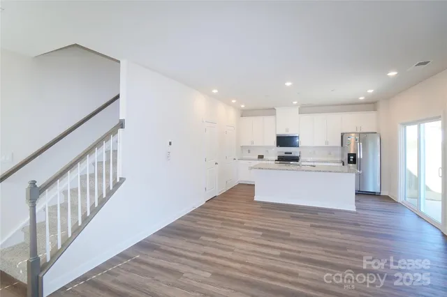 a view of kitchen with wooden floor and electronic appliances