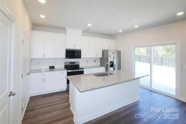a kitchen with sink stove and refrigerator