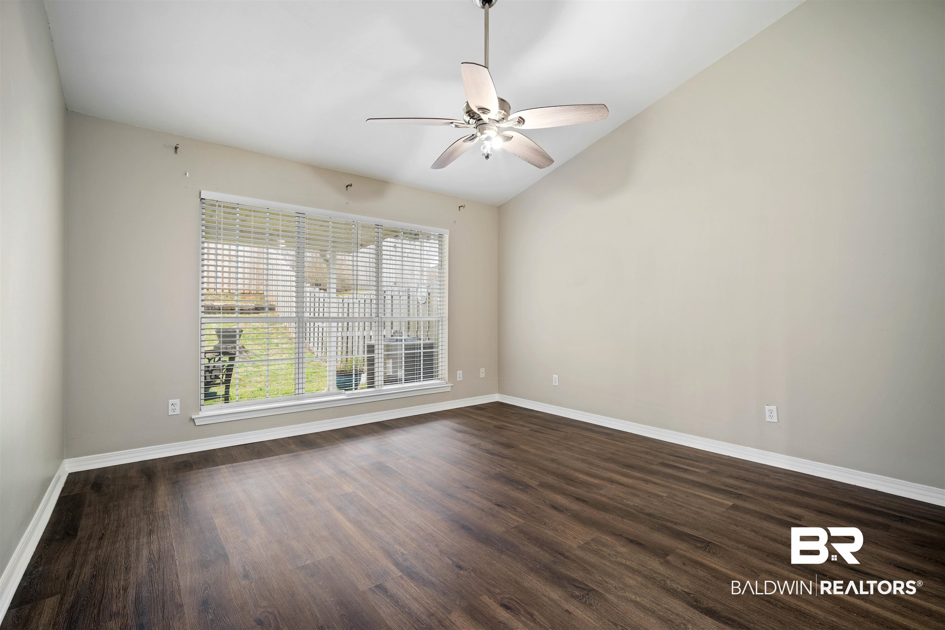 628 Spring Lake Court Mobile, AL 36695 - Photo 17 of 25 Unfurnished room with vaulted ceiling, dark hardwood / wood-style floors, and ceiling fan