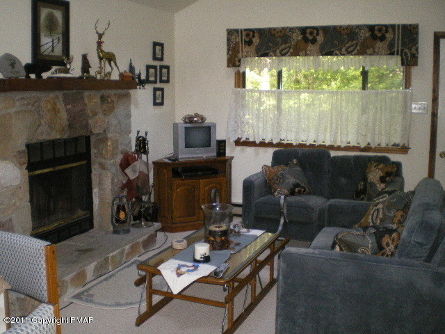 335 Fawn Road Pocono Lake, PA 18347 - Photo 2 of 12 a living room with furniture a flat screen tv and a fireplace