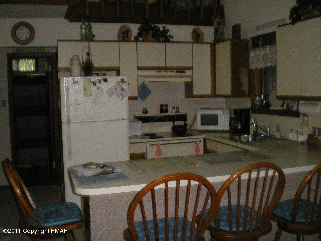 335 Fawn Road Pocono Lake, PA 18347 - Photo 4 of 12 a kitchen with stainless steel appliances granite countertop a sink a stove a refrigerator a washer and dryer