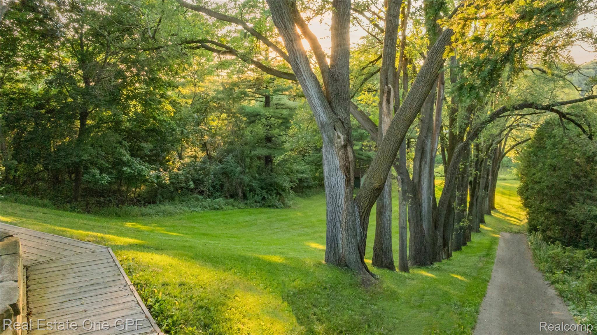 5068 Atkins Road North Street, MI 48049 - Photo 59 of 78 Manicured lawn with mature trees and a paved path