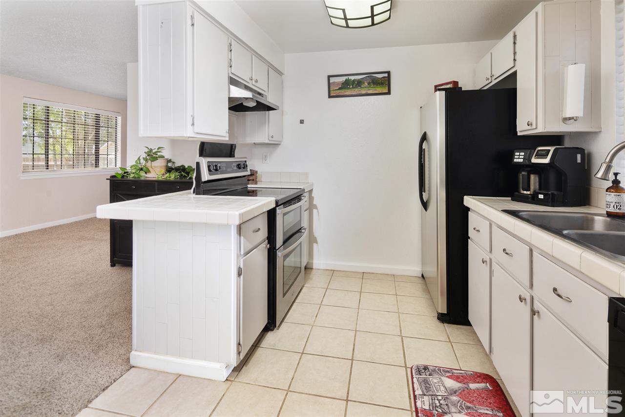 3600 Peregrine Court Reno, NV 89508 - Photo 11 of 36 a kitchen with stainless steel appliances granite countertop a refrigerator sink and stove