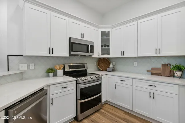a kitchen with kitchen island a sink and white cabinets