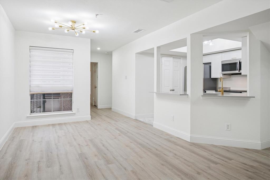5565 Preston Oaks Road, Unit 262 Dallas, TX 75254 - Photo 6 of 19 a view of empty room with wooden floor and fireplace