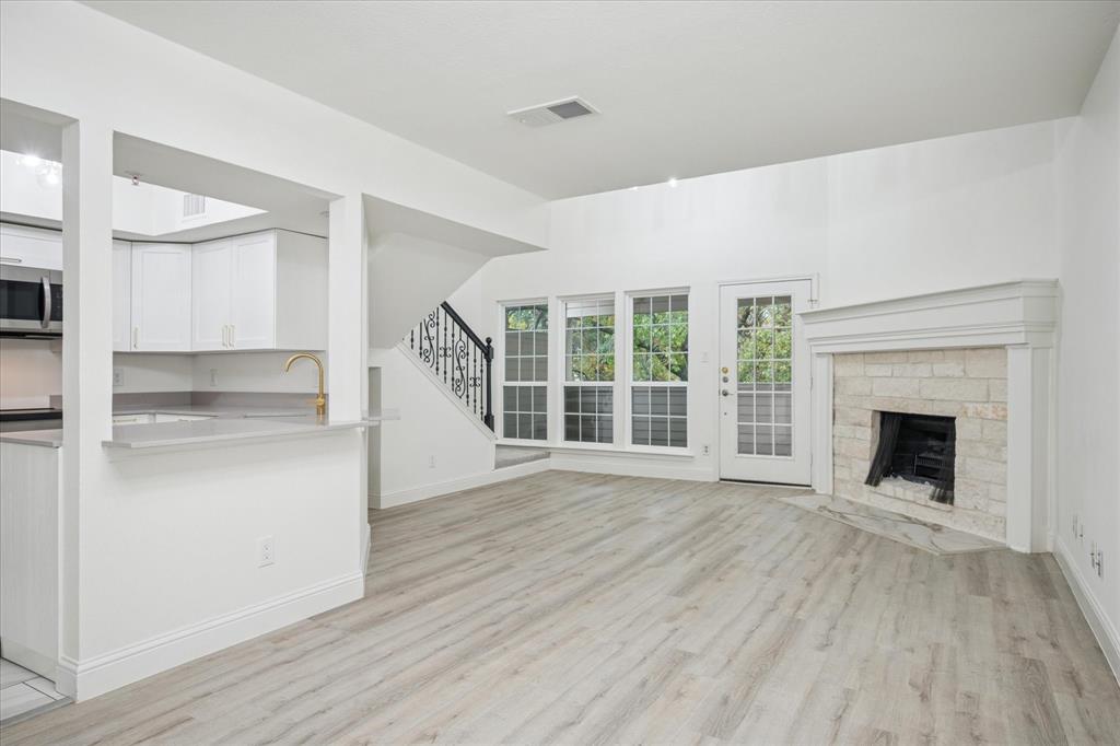 5565 Preston Oaks Road, Unit 262 Dallas, TX 75254 - Photo 7 of 19 a big room with wooden floor a fireplace and windows
