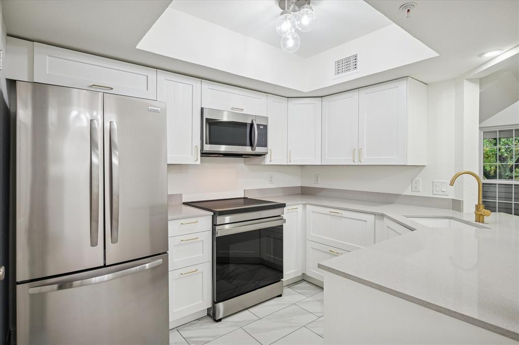 5565 Preston Oaks Road, Unit 262 Dallas, TX 75254 - Photo 10 of 19 a kitchen with stainless steel appliances a refrigerator sink and microwave