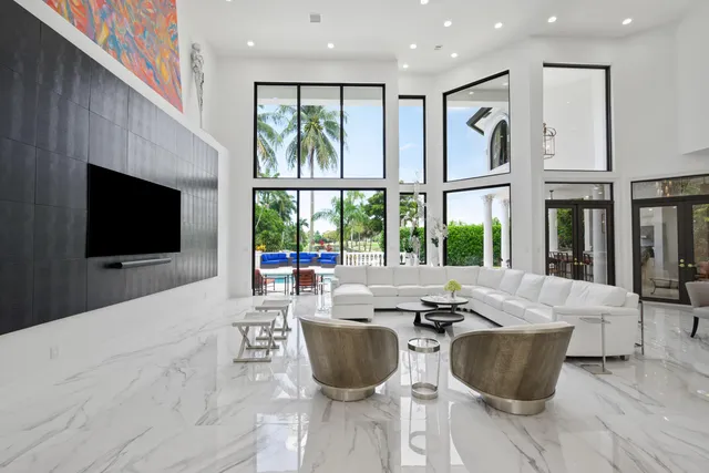 a living room with furniture a large window and a fireplace