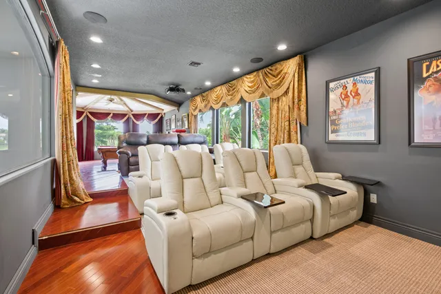 a media room with lots of chairs and a chandelier
