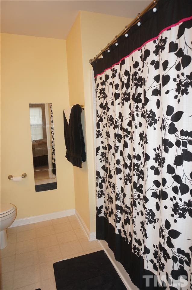 1722 Sorrell Brook Way Raleigh, NC 27609 - Photo 14 of 18 a bathroom with a toilet and a shower curtain