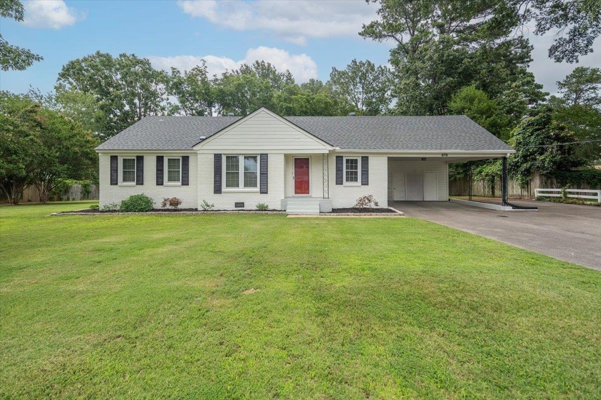 670 Peterson Lake Road Collierville, TN 38017 - Photo 27 of 37 White brick single-story residence featuring a dark shingle roof, red entry door, and black window shutters